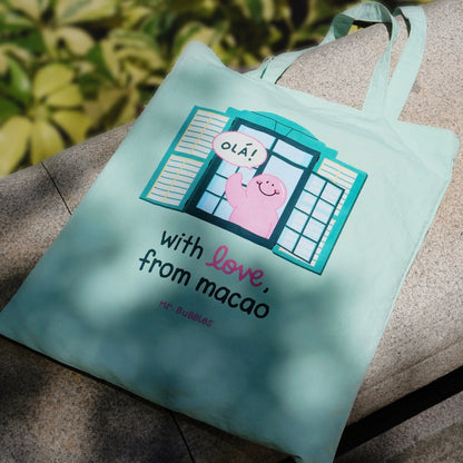Mr.Bubbles character peeking from Macau green colonial building on mint tote bag