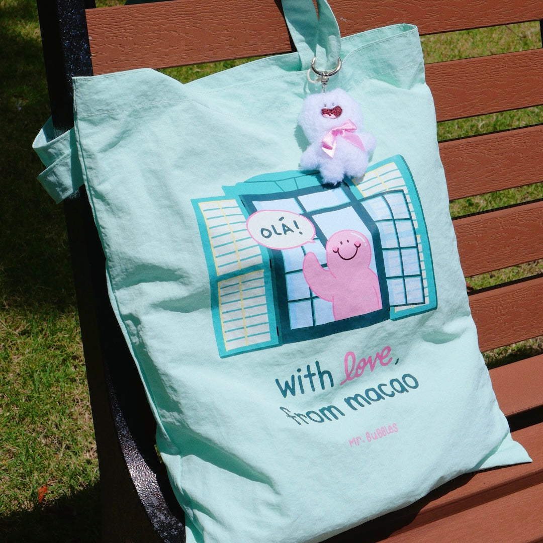 Mr.Bubbles character peeking from Macau green colonial building on mint tote bag